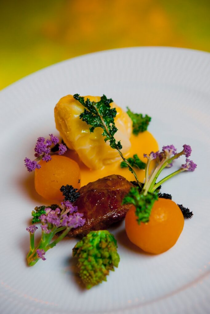 a white plate topped with vegetables and meat